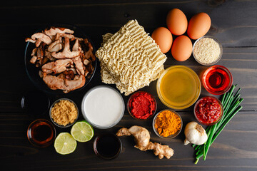 Spicy Coconut Curry Ramen Ingredients on a Wooden Table: Instant ramen noodles, shiitake mushrooms, curry paste, and other ingredients