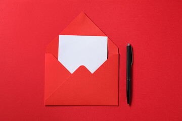 Blank sheet of paper, letter envelope and pen on red background, top view. Space for text