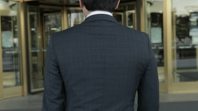 건물 입구로 걸어가는 정장입은 비지니스맨 뒷모습 카메라 추적 슬로우모션(회전문+빌딩+도시+남성+유리문)