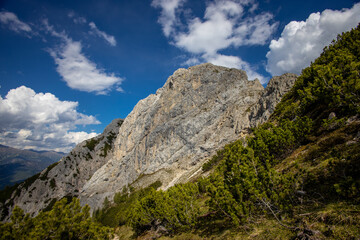 Dolomites mountains, Alpi Dolomiti beautiful scenic landscape in summer. Italian Alps mountain summits and rocky peaks above green valley alpine scene