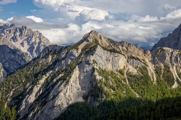 Dolomites mountains, Alpi Dolomiti beautiful scenic landscape in summer. Italian Alps mountain summits and rocky peaks above green valley alpine scene