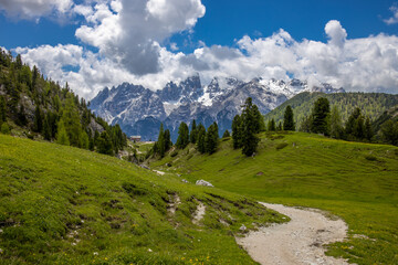 Dolomites mountains, Alpi Dolomiti beautiful scenic landscape in summer. Italian Alps mountain summits and rocky peaks above green valley alpine scene