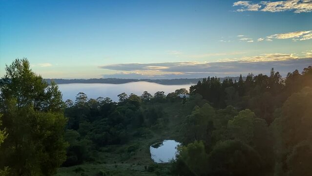 Breath taking dawn sunrise in the Sunshine Coast Hinterland at Maleny, Queensland with fog flowing and boiling through the valley as the sun comes up illuminating the drifting fog