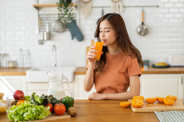 Portrait of beauty healthy asian woman making orange fruit smoothie with blender.girl preparing...