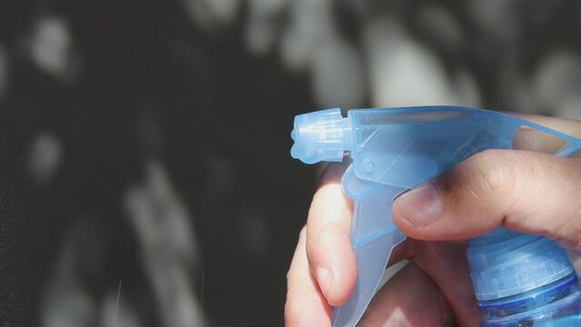 A person uses a blue vaporizer. The liquid is ejected