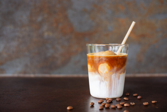 a glass of iced latte coffee on rustic table background.