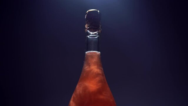 bottle of luxury champagne with golden shiny glitter and fizz, iridescent red sparkling wine on black background studio shot, fancy alcohol with glossy particles