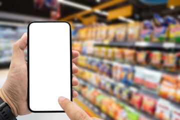 Hand holding blank screen smartphone for copy space on blurred Miscellaneous Product shelf. e-commerce app shopping mockup. social media, payment and shopping online concept.