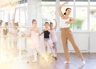 Female teacher dancer performing pirouette in front of class © JackF