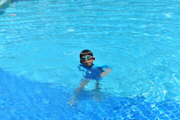 cute boy swimming in the pool, happy child