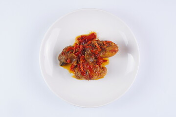 Indonesian typical balado fried chicken on a white plate on a white background with studio lighting