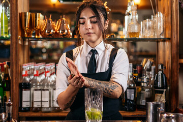 Female bartender preparing a cocktail in a traditional cocktail bar