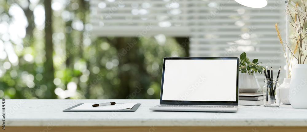 Canvas Prints a close-up image of a laptop computer white-screen mockup on a white table in a modern office room.
