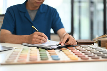 Unrecognizable senior male Interior designer choosing best paint for home refurbishment