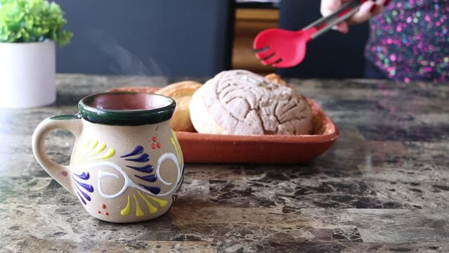 Slider of person placing bread behind cup of coffee, Mexican food. Breakfast