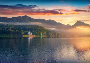 Foggy summer sunrise on Grundlsee lake. Amazing morning view of Gessl village, Liezen District of Styria, Austria, Alps. Europe. Traveling concept background..