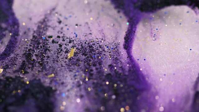 Glitter fluid spill. Shiny gloss. Blur purple black white color shimmering metallic sequin gold particles translucent paint liquid ink water flow motion abstract art background.