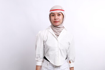 Happy young veiled Asian muslim woman is smiling, isolated on white background. Indonesian independence day concept