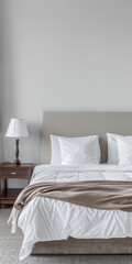 Modern hotel room with elegant bedding and stylish decor. Neutral tones and use of natural light.