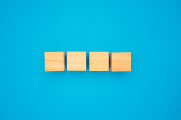 Four wooden cubes are on a blue background.
