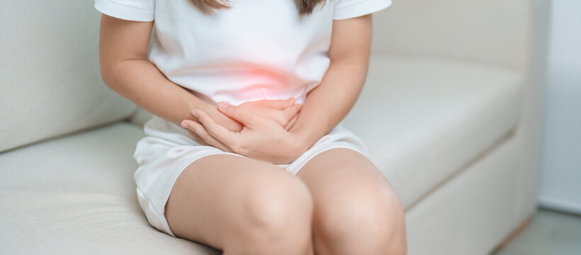 woman having abdomen ache due to Stomach pain, digestion with constipation or Diarrhea from food poisoning, female problem and Endometriosis, Hysterectomy, Stomachache and Menstrual on sofa at home
