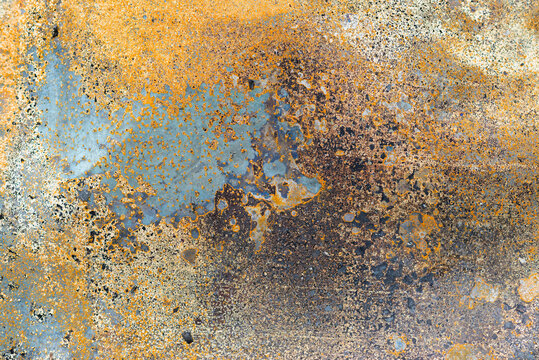 Rusty metal surface with weathered texture in orange, brown, and blue tones, ideal for industrial, grunge, or abstract backgrounds