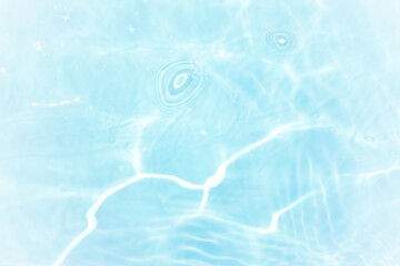 Blue water with ripples on the surface. Defocus blurred transparent blue colored clear calm water surface texture with splashes and bubbles. Water waves with shining pattern texture background.	