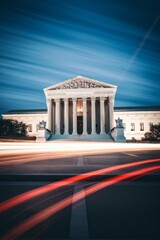 Obraz premium The Supreme Court building is a large, white structure with pillars and a dome. The building is surrounded by a white fence and has a large staircase leading up to the entrance