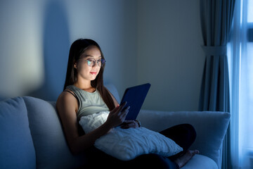 Woman with glasses and watch on tablet computer at home