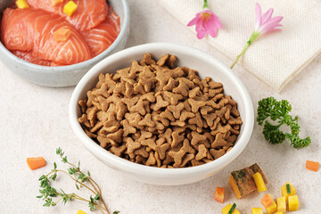 Dry cat ​​food is pellets in a white cup.