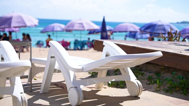 Chairs and Sun umbrellas on the sandy beach sea with crowds in holiday