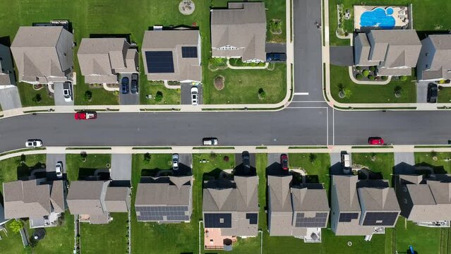 Aerial top down shot of American neighborhood with houses with rooftop solar panel arrays. Clean, renewable energy incentives in middle class housing developments in USA.