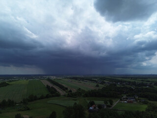 Storm clouds looming over green fields in the countryside