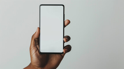 Hand delicately holding a phone with a blank white screen against a minimalist backdrop, conveying simplicity and modernity.

