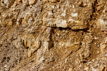 View of a wall at a stone quarry with limestone and crumbling dried clay. Lower Carboniferous, Russia