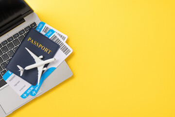 A passport and airplane tickets placed on a laptop, representing preparation for summer travel and...