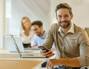 Startup handsome beard man with team member smiling at camera in office smartphone in hand