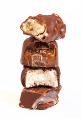 Assorted chocolates, bitten to reveal selection of fillings stacked on-top of each other. Isolated on white with copy space