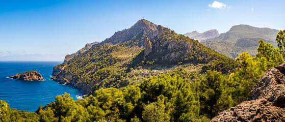 Panoramic view over the Serra de Tramuntana mountain range bordering the Mediterranean Sea near Port de Sóller, showcasing stunning views of Mallorca coastline and highest peaks on a sunny spring day.