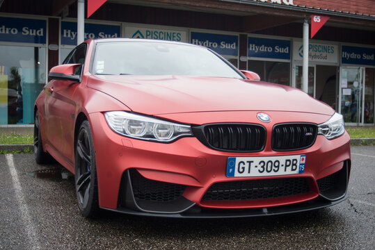 Mulhouse - France - 4 june 2024 - front view of red BMW M4 parked in the street by rainy day