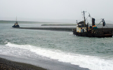 Two fishing vessels in shallow water. Stormy weather. Saltwater fishing industry