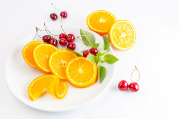  A burst of sunshine on a plate: Vibrant orange slices and ruby red cherries fill a white dish, their contrasting colors hinting at a refreshing and exotic juice.