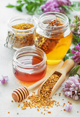 Raw organic bee pollen and honey in jars.