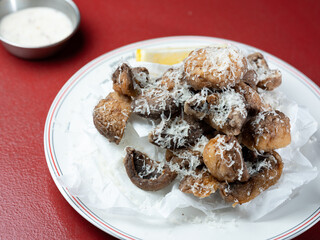 Fried button mushrooms with cheese on a plate