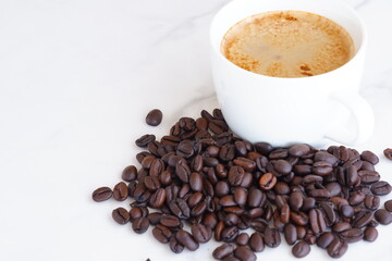 エスプレッソに牛乳をたっぷり入れたコーヒーのカフェ・ラッテと、深煎りしたコーヒー豆
