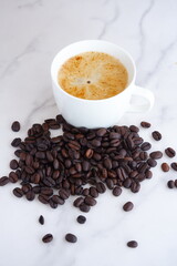 エスプレッソに牛乳をたっぷり入れたコーヒーのカフェ・ラッテと、深煎りしたコーヒー豆
