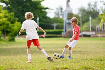 Child playing football. Kids play soccer.