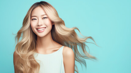 Fototapeta premium Portrait of a beautiful, sexy, smiling, happy blonde Asian woman with long hair and perfect skin, light blue background, banner.