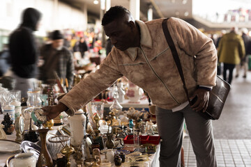 South African man selects antiques at a flea market