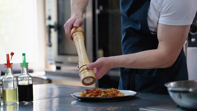 Chef adds salt to asian dish. Cooking fried vegetables. Asian cuisine